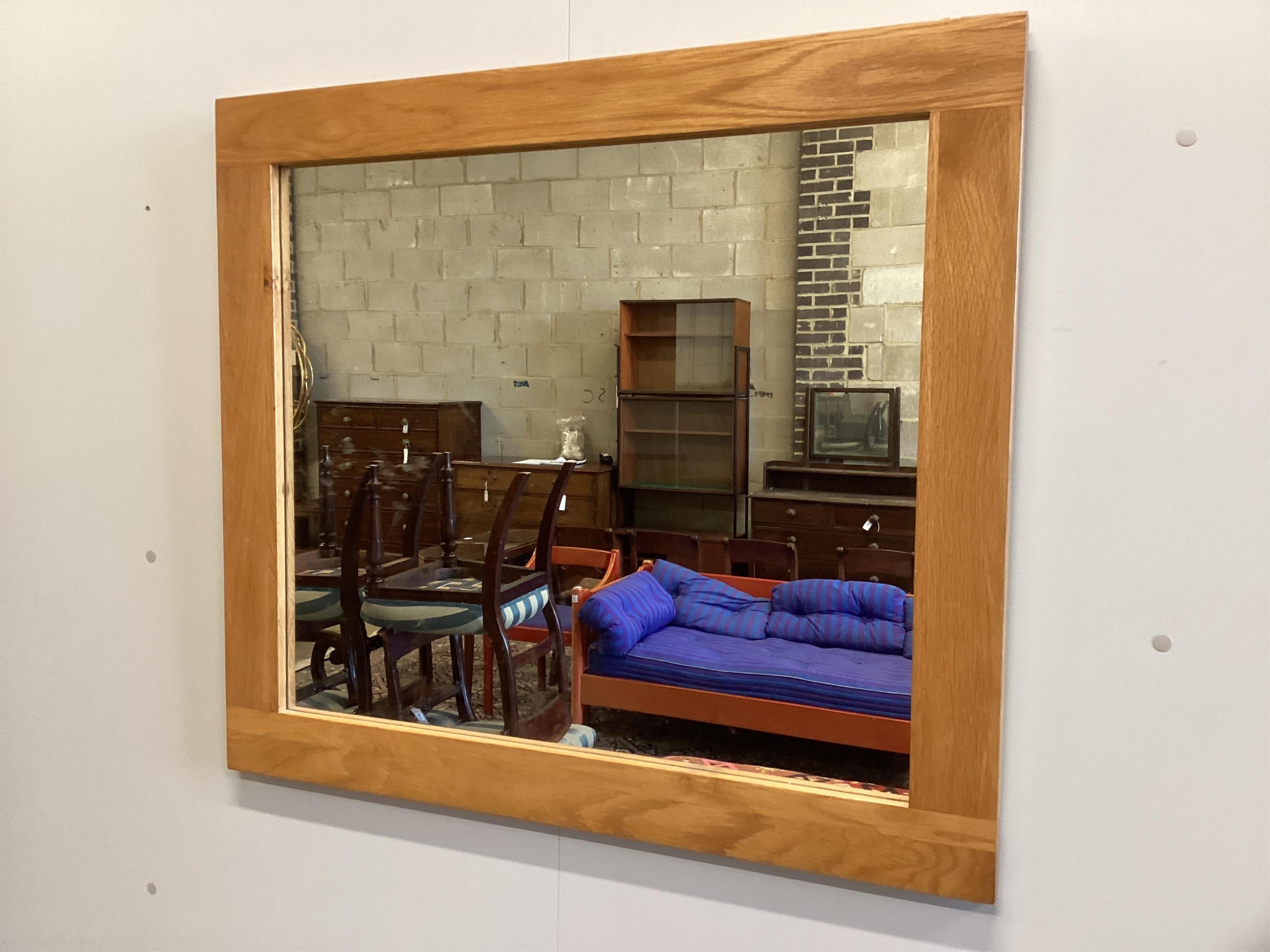 A contemporary rectangular oak wall mirror, width 90cm, height 80cm. Condition- good.